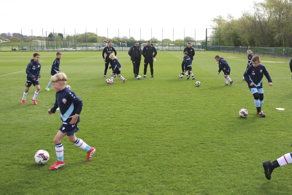 Under 8s dribbling drill in front of Steven Schumacher
