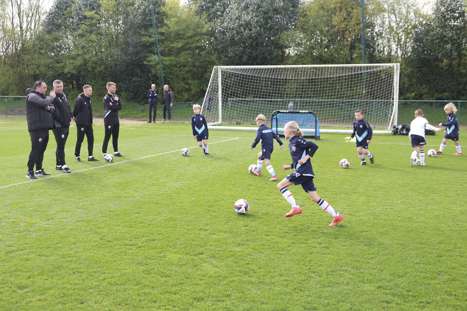 Under 8s dribbling drill in front of Steven Schumacher