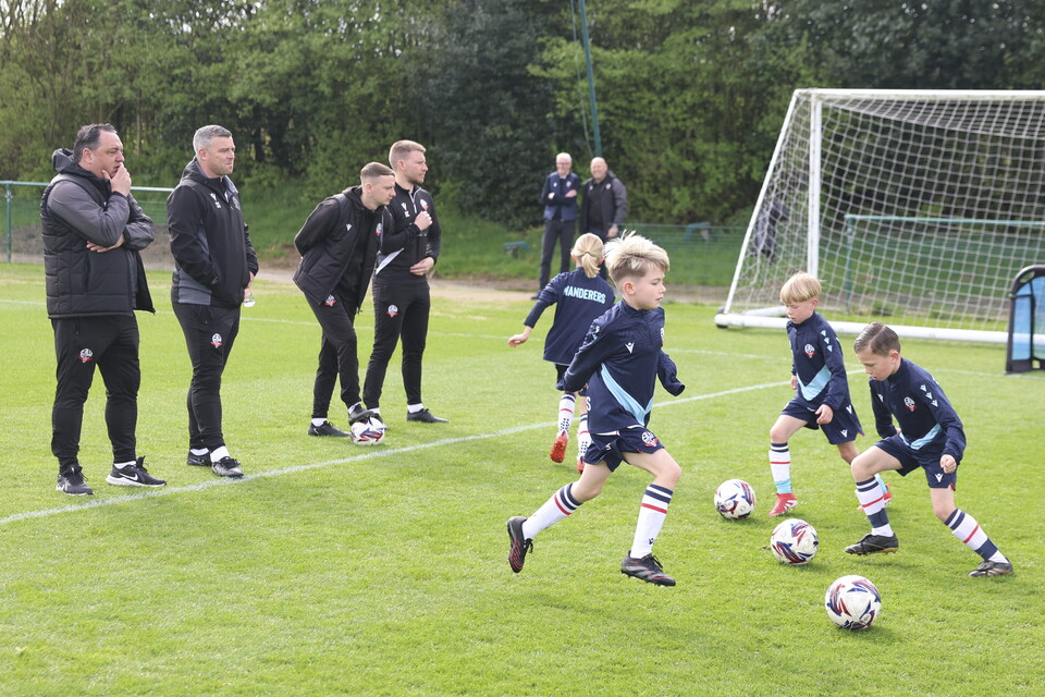 Under 8s dribbling drill in front of Steven Schumacher