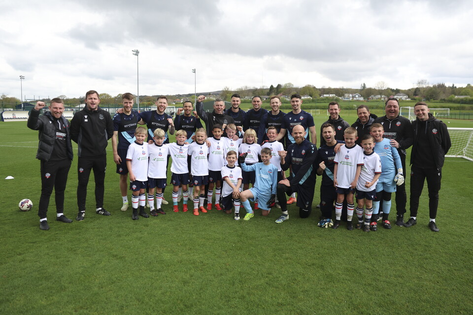 Under 8s posing for a photo with academy and first team coaches and management